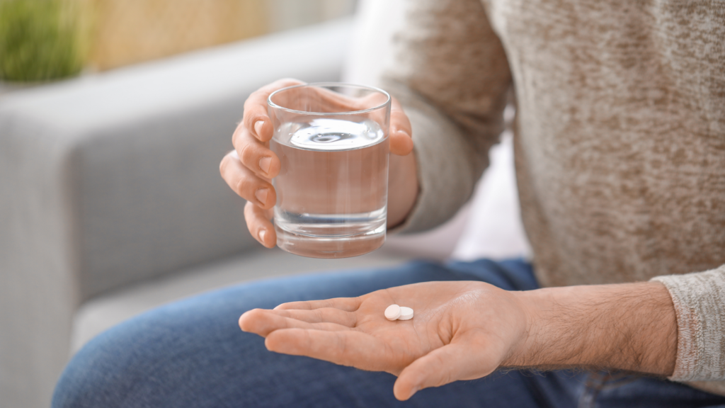 Pessoa segurando medicamento antidepressivo e copo de água
